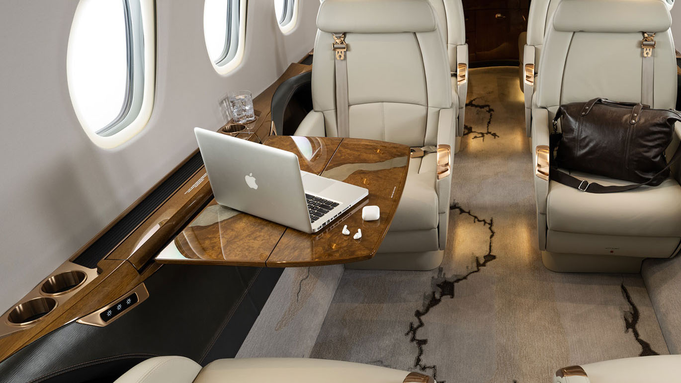 Computer and ear buds on a table inside aircraft.